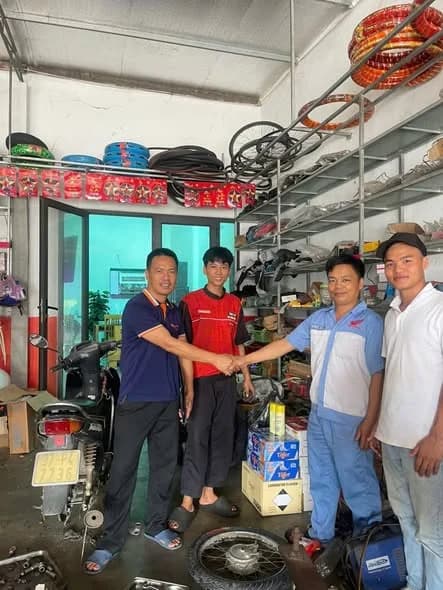Đại diện công ty bắt tay chủ cửa hàng phụ tùng