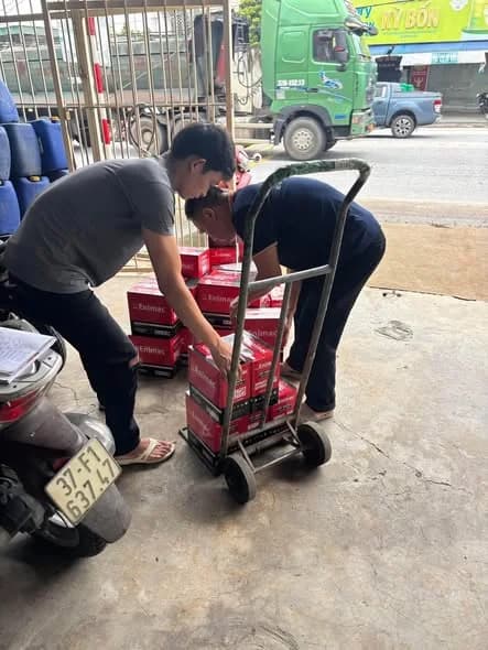 Nhân viên dùng xe đẩy bốc ắc quy xuống cửa hàng